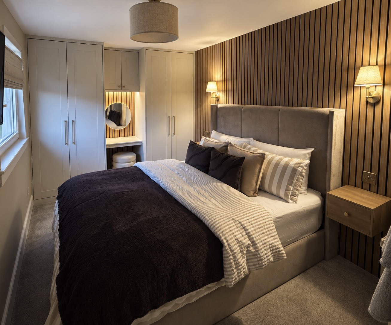 Bedroom with slatted wall panelling, handmade wardrobes and a fitted dresser