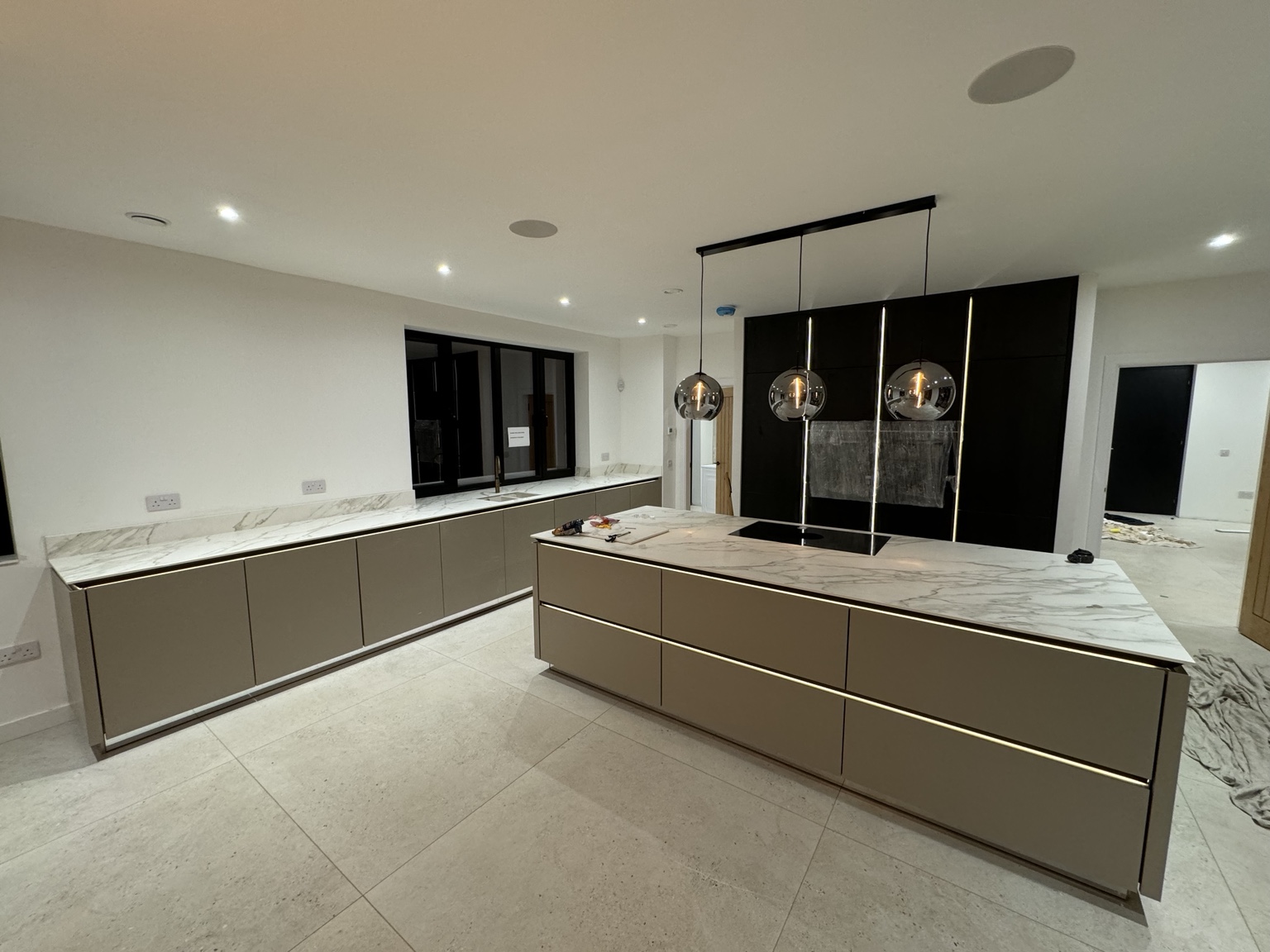 Modern kitchen with a large island, marble-effect worktops and pendant lighting